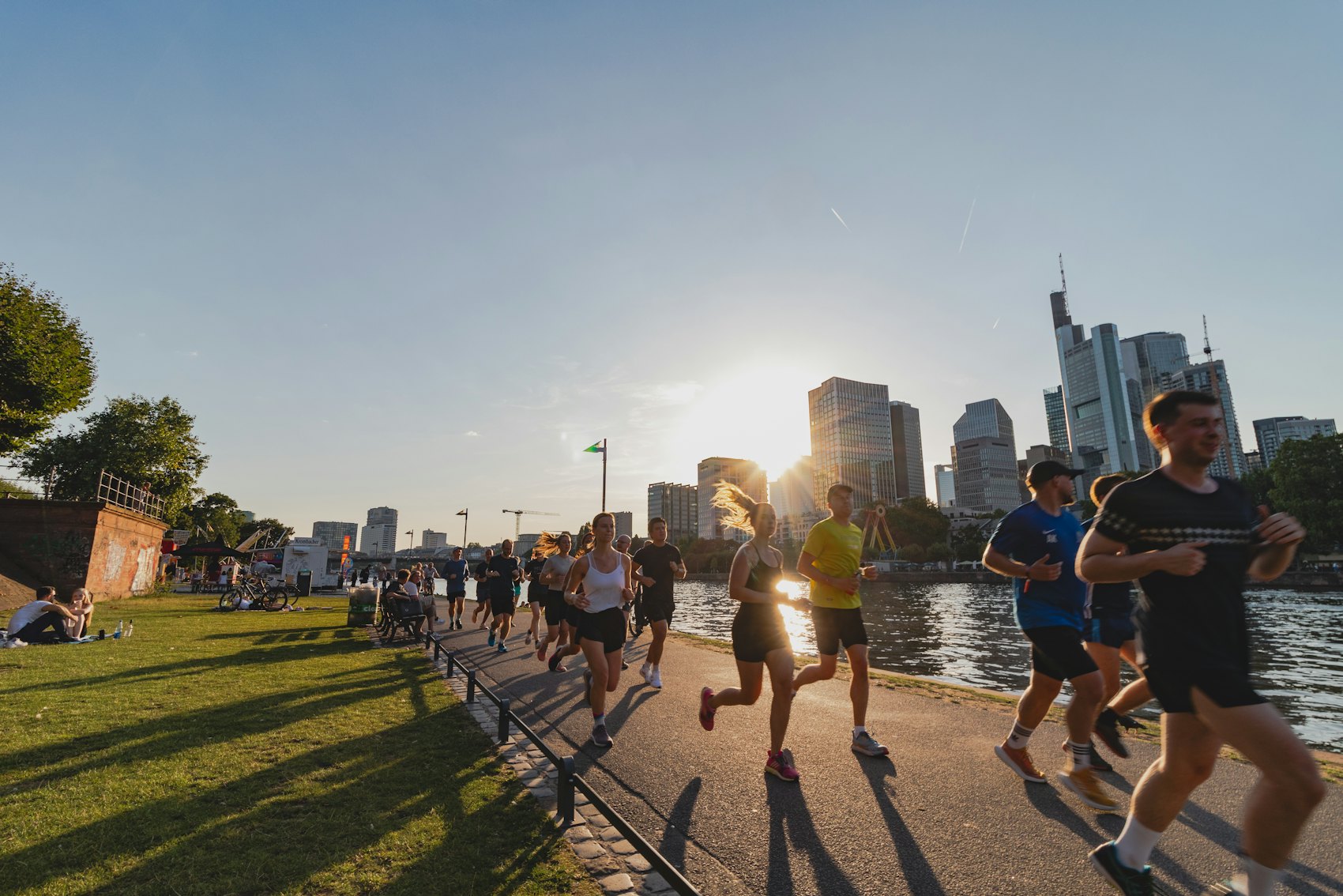 A runner along the waterfront as the city skyline glows at dusk